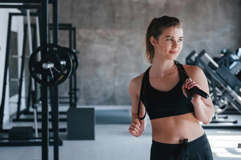 Woman exercising with jump rope in gym.