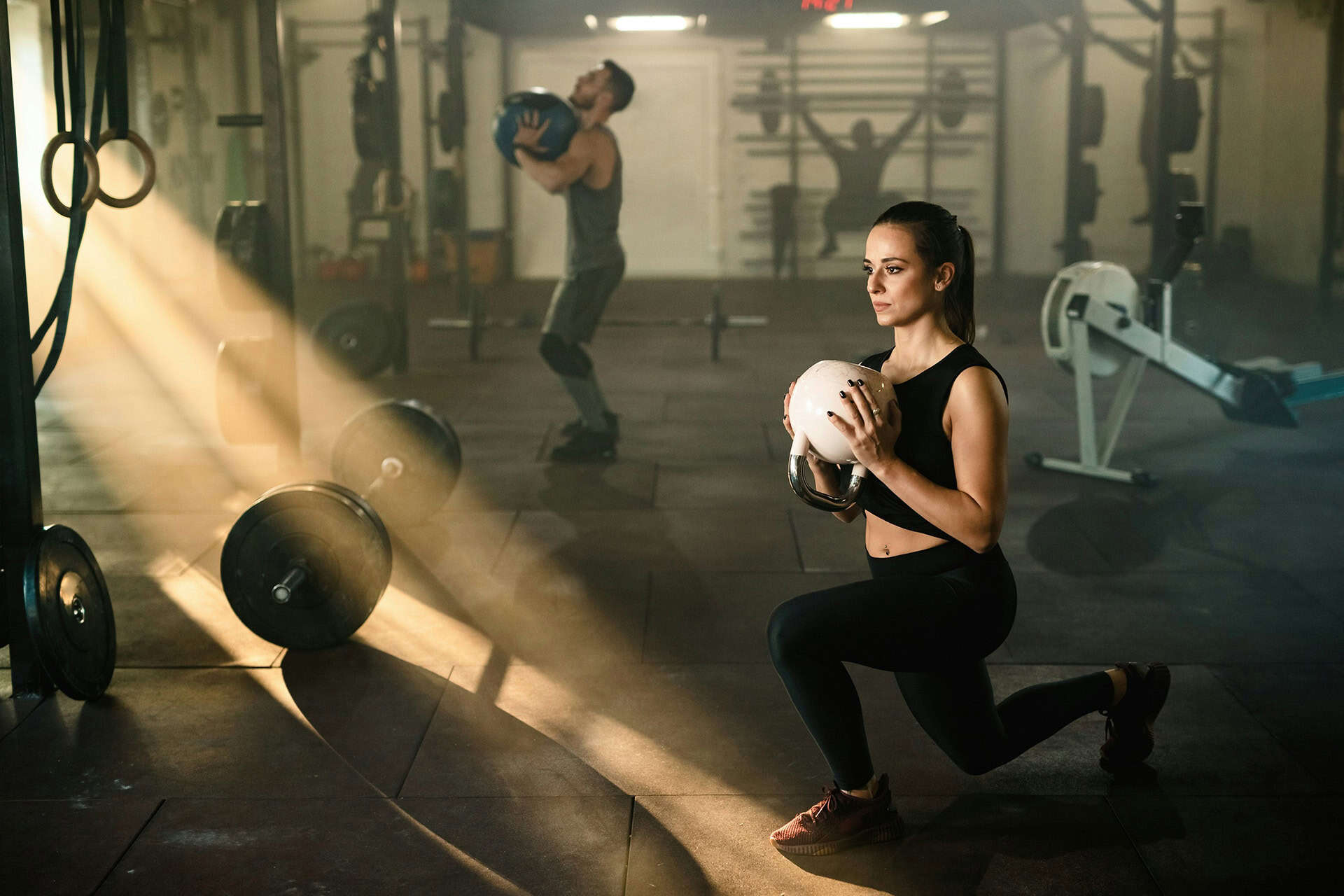 People exercising with medicine balls in gym.