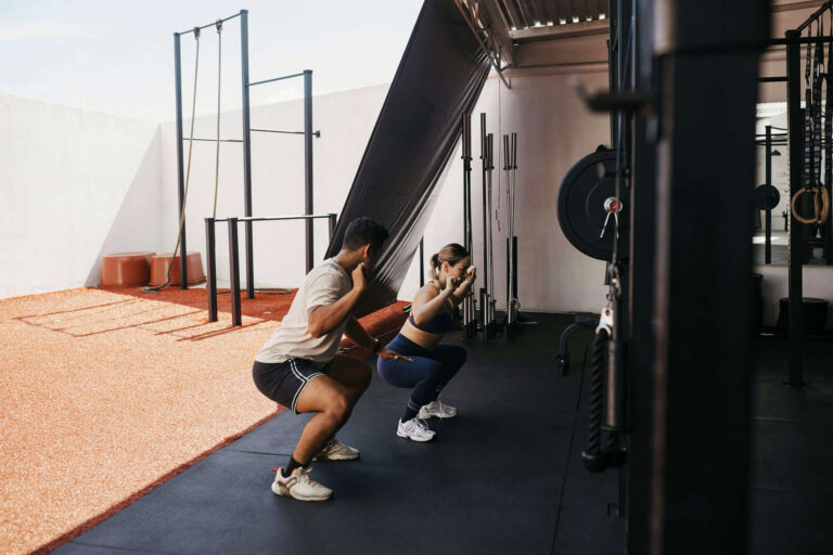 Two people exercising in a gym together.