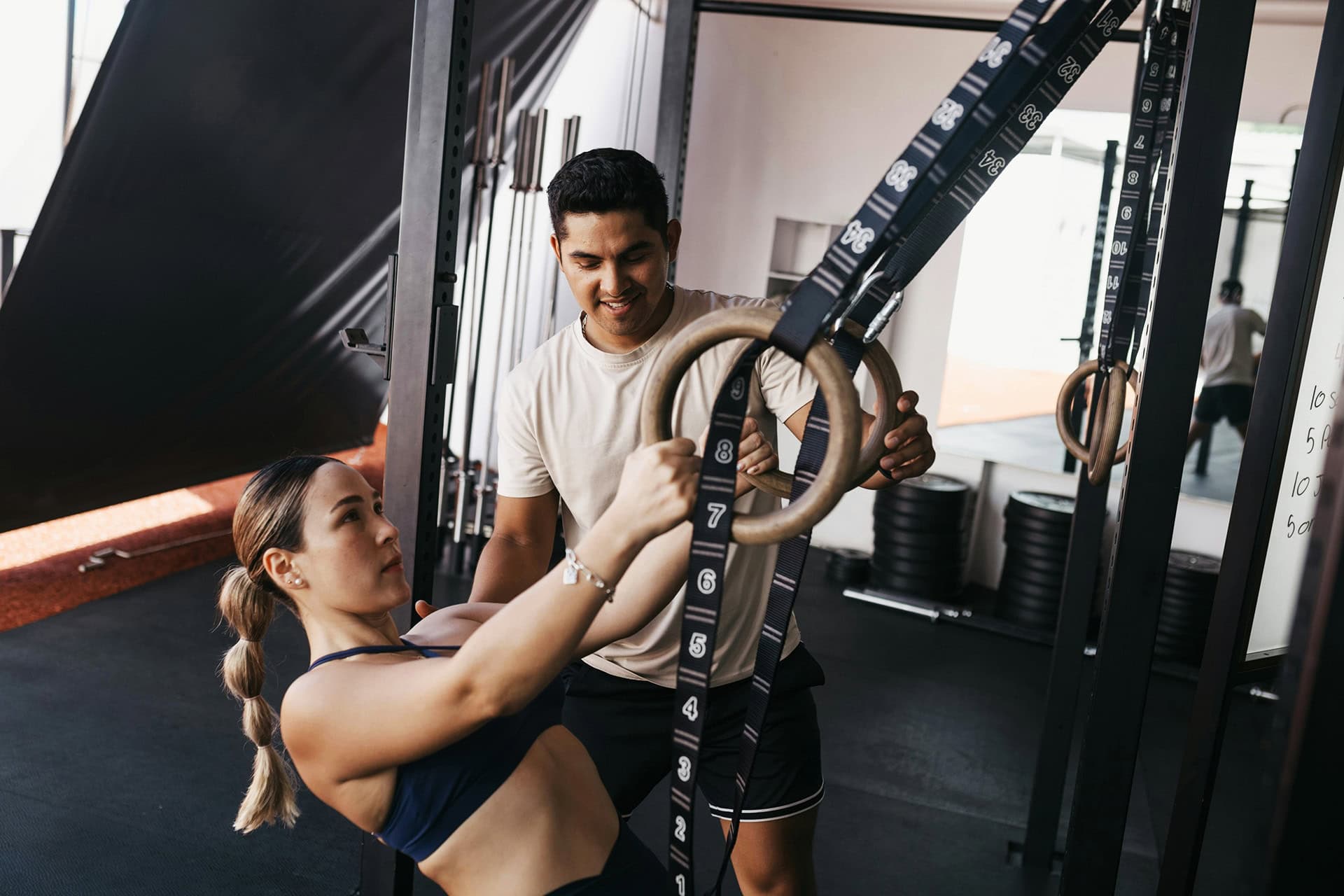 Woman training with gymnastic rings, assisted exercise.