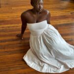 woman in white dress sitting on the hardwood floor